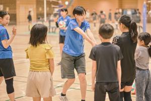 画像:小学生体験会で選手からバレーボールを教わっているところ