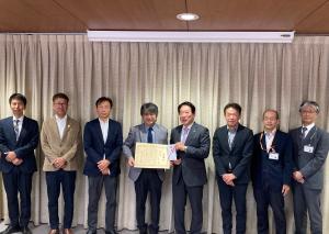 画像：東京三鷹ロータリークラブの皆様（左側）と河村市長（中央）が感謝状と目録を持って並んでいる様子