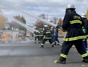 画像：消防署隊と消防団隊による一斉放水をしている様子の写真（拡大画像へのリンク）
