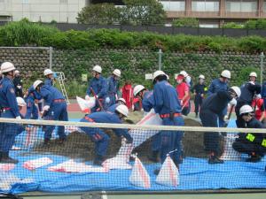 画像：三鷹市消防団・三鷹市職員による土のうの作成（拡大画像へのリンク）