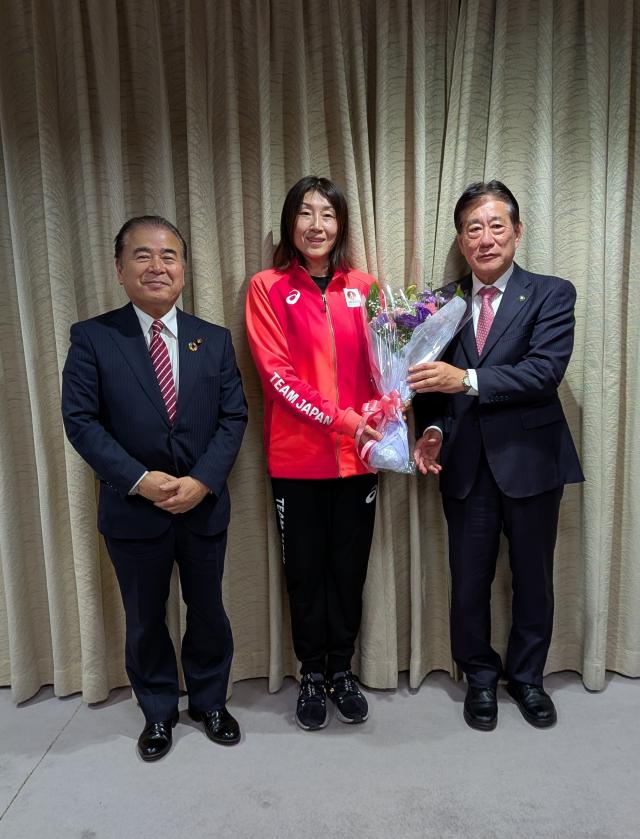 画像：市長から贈呈された花束を掲げた出席者の集合写真