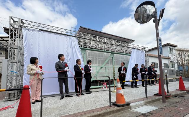 画像：除幕式で幕を開けている様子