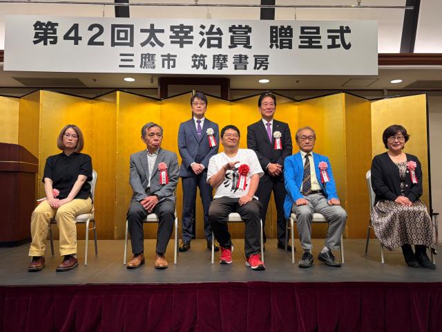 画像：受賞者のこがわゆうじろうさん（前列中央）を囲んで記念写真