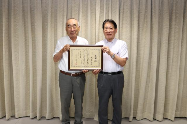 画像：河村市長から贈呈された感謝状を掲げた会長
