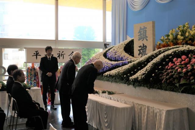 画像：献花台に向かって献花をする遺族会会長と前会長