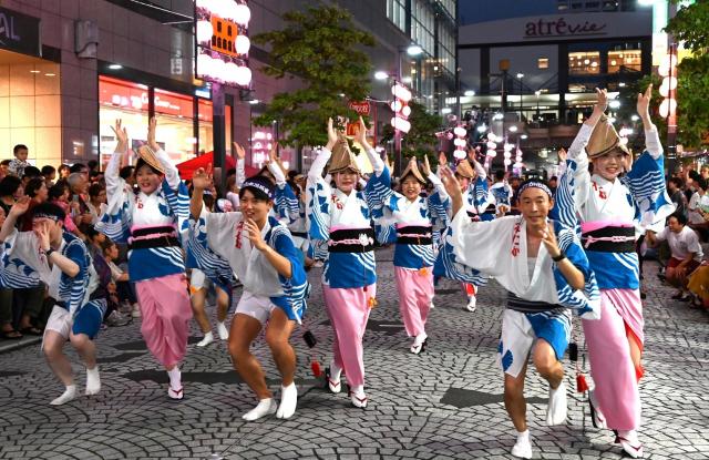 画像：多くの観客に囲まれながら踊り手たちが力強く踊っている