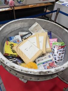 画像：チラシなどが入っているタイムカプセルの中の写真（拡大画像へのリンク）