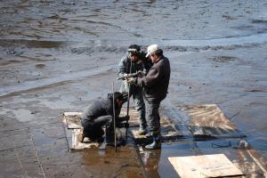 画像：写真・泥の上に浮かべた足場上での採取作業風景（拡大画像へのリンク）