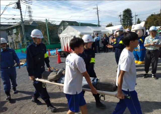 画像：救助された人を担架で搬送する訓練をしている写真