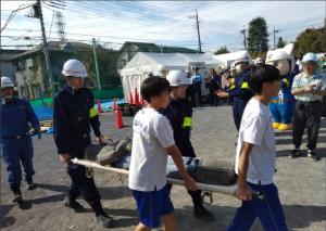 画像：救助された人を担架で搬送する訓練をしている写真（拡大画像へのリンク）