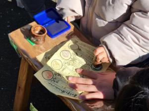 画像：春の七草スタンプラリーのスタンプを押している子どもの様子（拡大画像へのリンク）