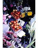 墓前に供えられた桜桃や花、煙草などの写真