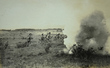 煙の中、歩兵銃を手に前進している写真
