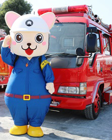 画像：消防車の前に立つ着ぐるみの「じじょまる」